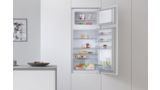 Встариваемый холодильник Bosch, шириной 60 см, с открытой дверцей, показаны продукты и напитки внутри.