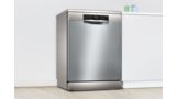  Bosch samostojeća mašina za pranje sudova sa završnim izgledom u stilu nerđajućeg čelika u beloj kuhinji.