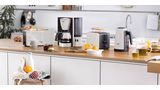 Set ComfortLine v bielej s toasterom, filtračným kávovarom a kanvicou. Stôl s bohatými raňajkami.