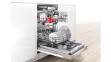 Lave-vaisselle 45 cm intégrable de Bosch avec une porte ouverte dans une cuisine élégante.