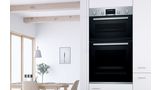 A Bosch double oven built into a wall in a modern white kitchen. 