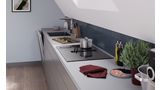 Hoekaanzicht van een keukenopstelling onder een schuin dak met een Bosch-kookplaat met geïntegreerde ventilatiemodule.