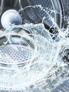 Nærbilde av vann som snurrer rundt inni en Bosch vaskemaskin.