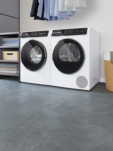 Augstas kvalitātes Bosch veļas mazgājamā mašīna un žāvētājs modernā vannas istabā.