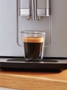 1 tasse remplie de café crème placée sur la cuvette d'égouttage de la machine VeroCafe Série 2.