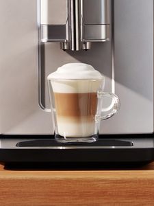 1 tasse remplie de cappuccino placée sur la cuvette d'égouttage de la machine VeroCafe Série 2.