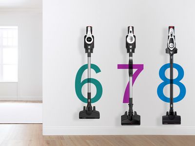 The three Unlimited cordless stick vacuums hanging on a wall next to the living room.
