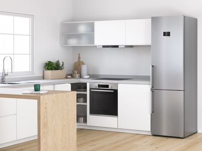 Samostojeći hladnjak sa zamrzivačem od nehrđajućeg čelika u svijetloj, modernoj kuhinji.