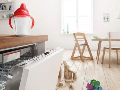 Lave-vaisselle Bosch encastrable ouvert dans une cuisine blanche moderne.