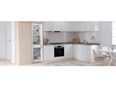 Stainless steel fridge freezer in a bright, modern kitchen.
