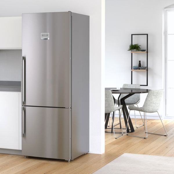 Geräumige Küche mit silbernem, integriertem Kühlschrank von Bosch. Moderner Essbereich im Hintergrund.