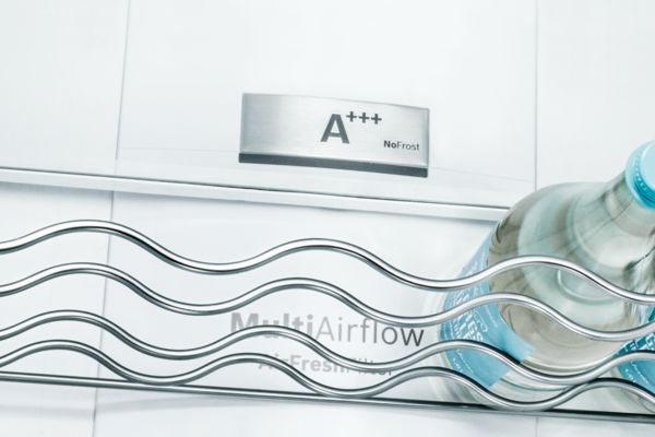 Nahaufnahme einer Flaschenablage und Wasserflasche in einem Bosch Kühlschrank. Zeichen A+++ zeigt die Energieeffizienz.