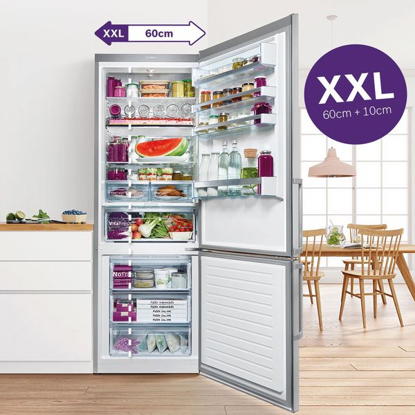 Відкритий великий холодильник Bosch з морозильною камерою на кухні. Наповнений свіжими продуктами. 