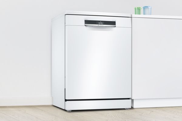 Freestanding white Bosch dishwasher in a white kitchen.