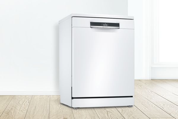 Bosch 白色獨立式洗碗機位於明亮的白色空間中。