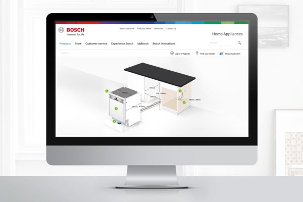 Desktopcomputer viser Bosch-website med præcise mål til professionel installation af opvaskemaskine.