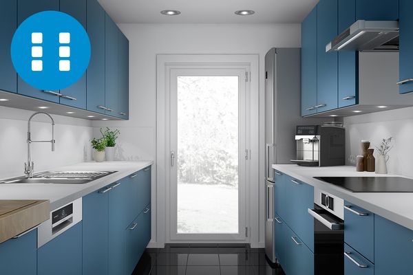 Kambīzes tipa virtuve ar zilas krāsas mēbelējumu un pilnībā izgaismotām ārējām stikla durvīm galā