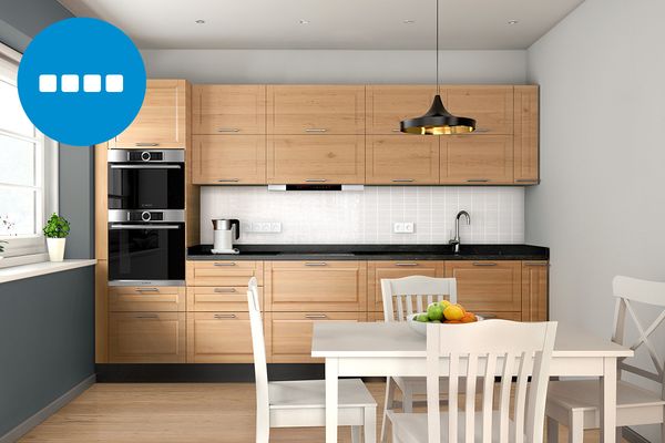 Bucătărie simplă, cu un perete, cu dulapuri din lemn de anin de culoare maro și un set de mobilier de sufragerie alb