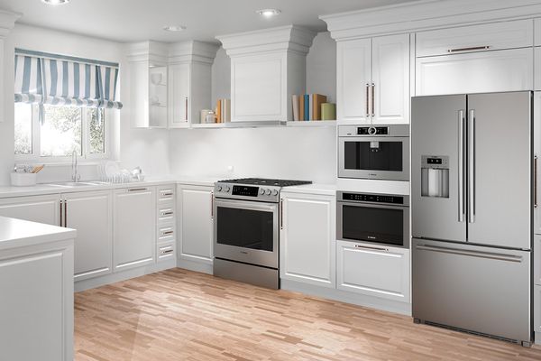 Bucătărie spațioasă în formă de U, cu electrocasnice din inox și dulapuri clasice albe cu plintă de tavan elegantă