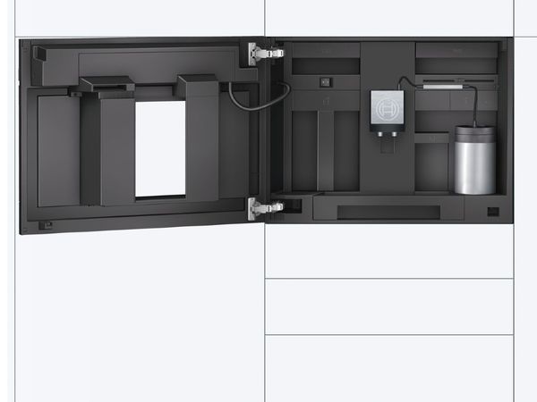 Nagyméretű, modern konyha, fehér felső és fekete alsó szekrényekkel, keskeny sárgaréz fogantyúkkal és beépített kávéfőzővel az előtérben
