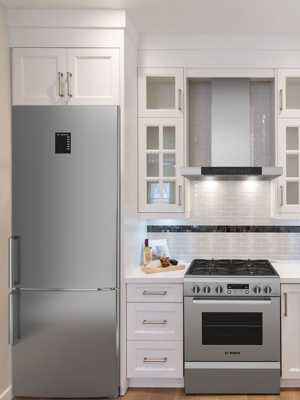 小型 L 形經典白色廚房，櫥櫃直達天花板，白色瓷磚後擋板上有醒目的黑色條紋
