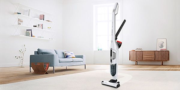 The cordless vacuum Flexxo stands in the middle of a room, the integrated accessories are visible.