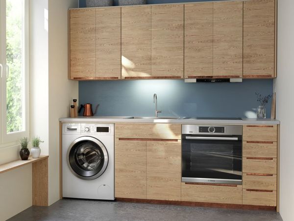 Jednoduchá a malá jednořadá kuchyň s nerezovými domácími spotřebiči a skříňkami v pískové barvě 1200x900