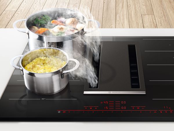 Steaming pots on an induction hob with an integrated ventilation module