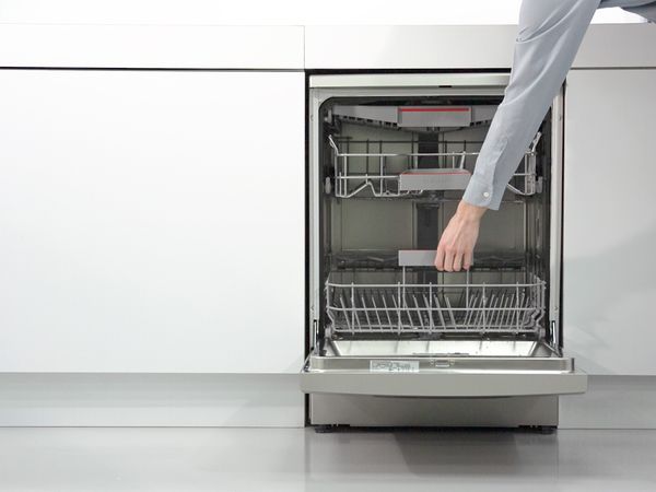 Osoba vadi sudove iz Bosch mašine za pranje sudova
