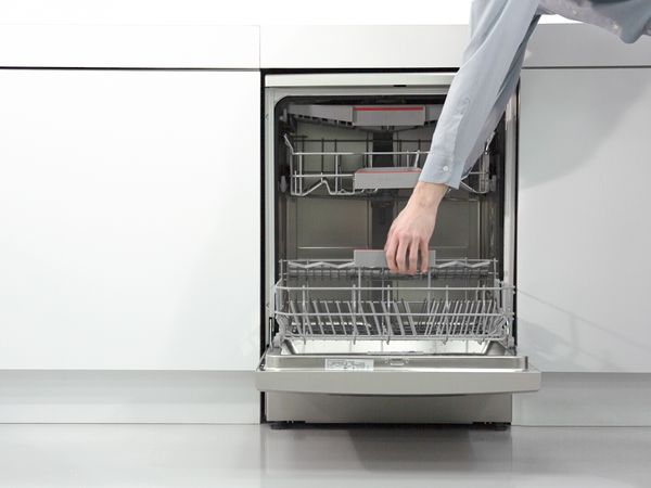 Hand removing the rack from a Bosch dishwasher