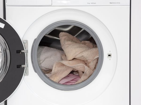 Отворете пералната машина на Bosch с много пране в барабана