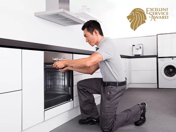 Technician repairing an oven from Bosch and the symbol of excellent service award.