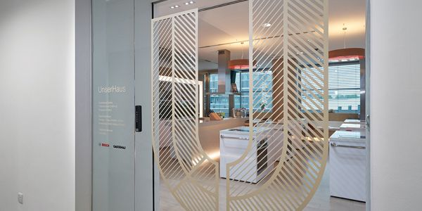 Entrance of the showroom Unserhaus in Singapore with glass door and comfortable seating.