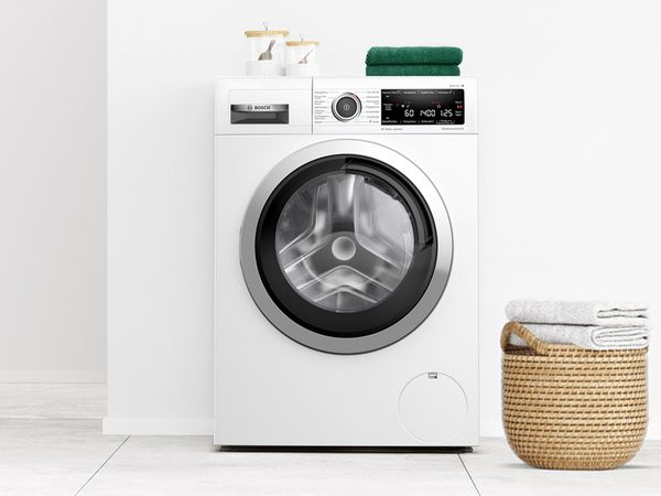 Máquina de lavar roupa de instalação livre da Bosch numa casa de banho branca moderna