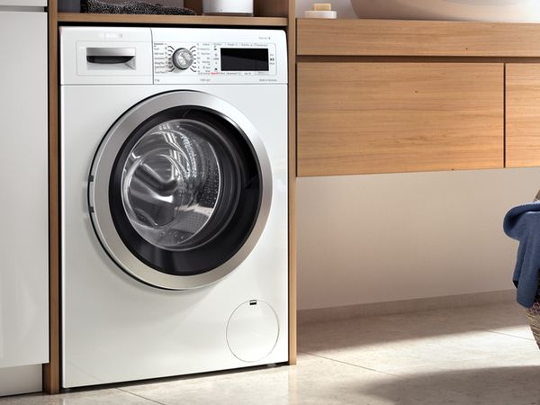 Standardowa pralka ładowana od przodu marki Bosch w nowoczesne białej łazience