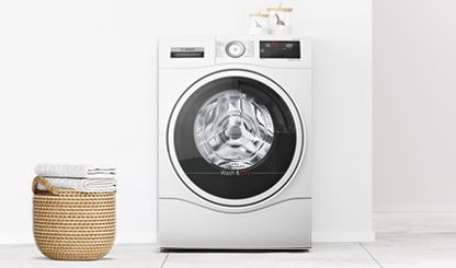 Bosch kombinert vask og tørk-apparat som kjører, og en skittentøyskurv til venstre