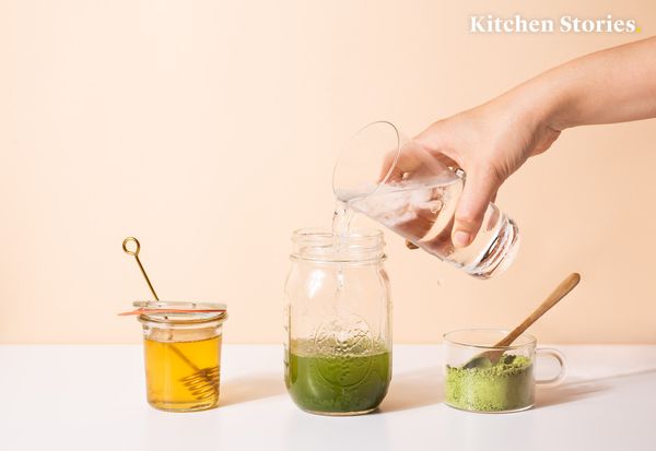 pouring water in a glass with matcha powder 