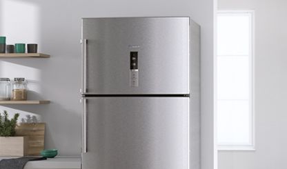 Ezüst színű, szabadon álló Bosch hűtőszekrény egy fehér konyhában. 