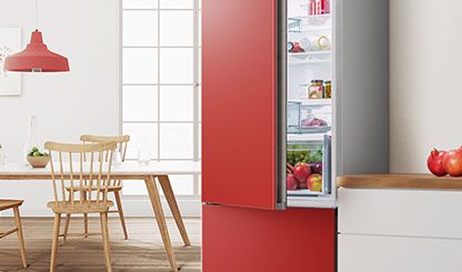 Rote Vario Style Kühl-Gefrier-Kombination von Bosch mit offener Tür gibt den Blick frei auf die frischen Lebensmittel im Inneren. 