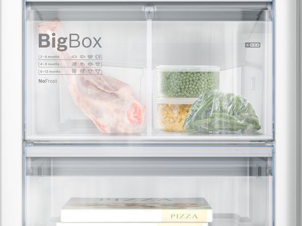 Prim-plan cu un congelator Bosch plin cu carne și legume. BigBox arată un congelator de mare capacitate.