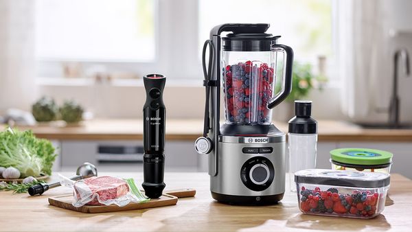 Pakujący próżniowo blender ręczny i blender marki Bosch na blacie kuchennym obok kompatybilnych pojemników.