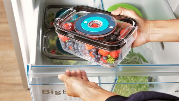 Vacuum sealed food being placed in a refrigerator where it stays fresh for longer.