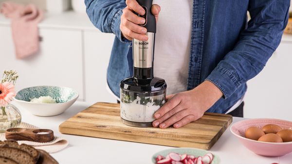Blender ręczny MaxoMixx używany do przygotowania hummusu w kuchni.