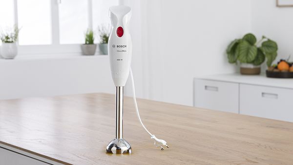 Bijeli Bosch štapni mikser CleverMixx na kuhinjskoj radnoj ploči od drveta.