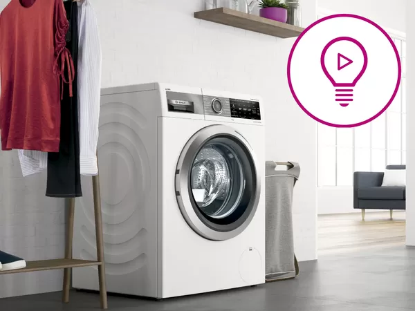 Bosch washing machine cleaner bottle positioned beside a sleek front‑loading washer in a neat, light‑filled laundry room highlighting maintenance, cleanliness, and appliance care.