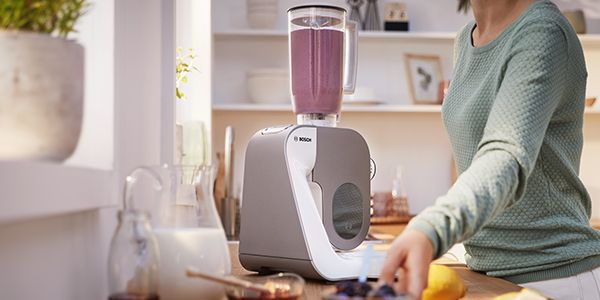Person using the MUM blender attachment to make a smoothie.
