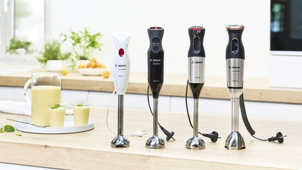 Lineup of Bosch hand blenders, from CleverMixx to MaxoMixx, on a kitchen worktop.
