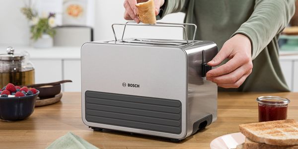 Eine Person nutzt einen Bosch Toaster mit Silikonauskleidung.