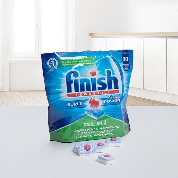 A package of Finish dishwasher tablets on the countertop of a modern kitchen.