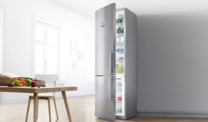 Sidabro spalvos laisvai statomas Bosch šaldytuvas-šaldiklis baltoje virtuvėje. 